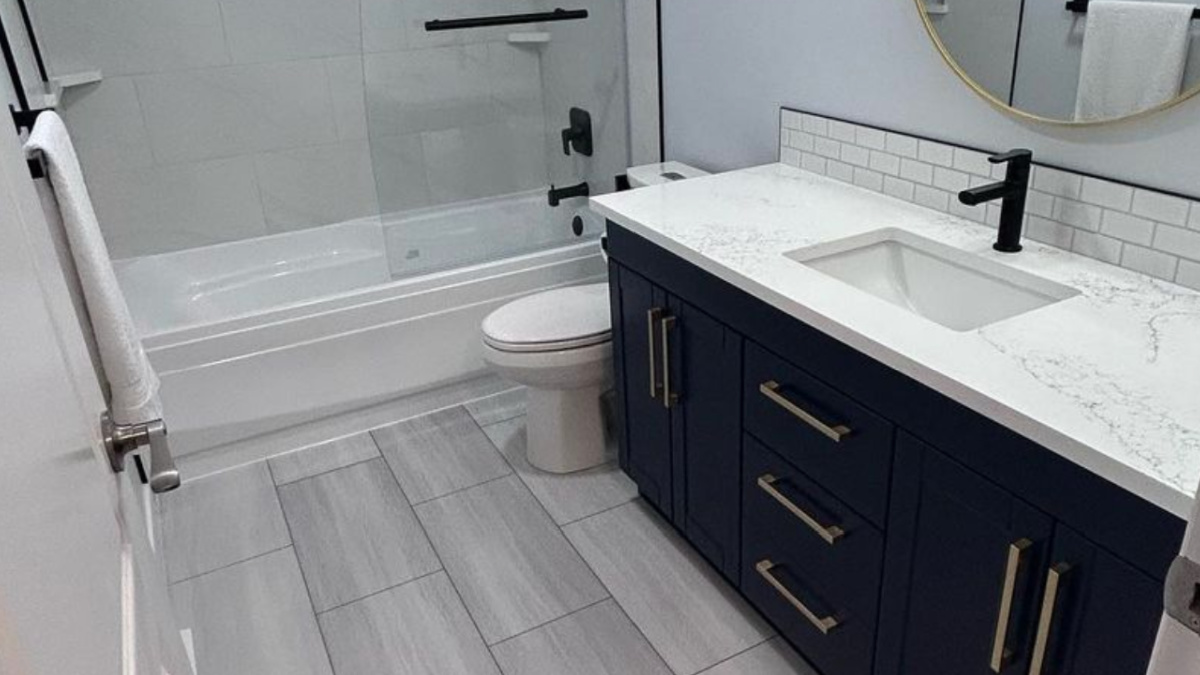 a bathroom renovation with a dark cabinet