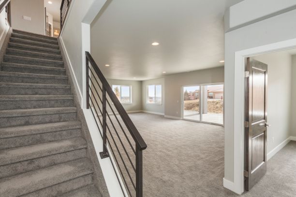 an empty finished basement with carpet